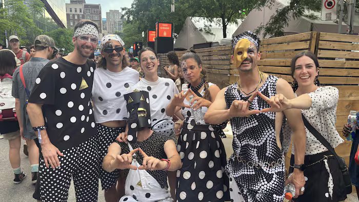 People wearing polka dots smile at the camera. 