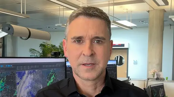 Jörg Heidermann in the office in front of screens with weather simulations.