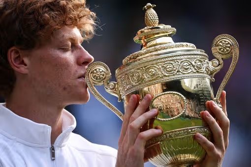 TOPSHOT - Italy's Jannik Sinner kisses the winner's trophy as he poses for photographs after defeating Spain's Carlos Alcaraz at the end of the men's singles final tennis match on day fourteen of the 2025 Wimbledon Championships at the All England Lawn Tennis and Croquet Club in Wimbledon, southwest London, July 13, 2025. (Photo by HENRY NICHOLLS/AFP) / RESTRICTED FOR EDITORIAL USE (Photo by HENRY NICHOLLS/AFP via Getty Images) 