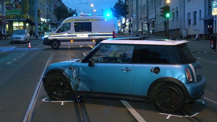 Following the accident, the Mini sits sideways on the tracks on Altendorfer Strasse in Essen. A police car can be seen blocking the road in the background.