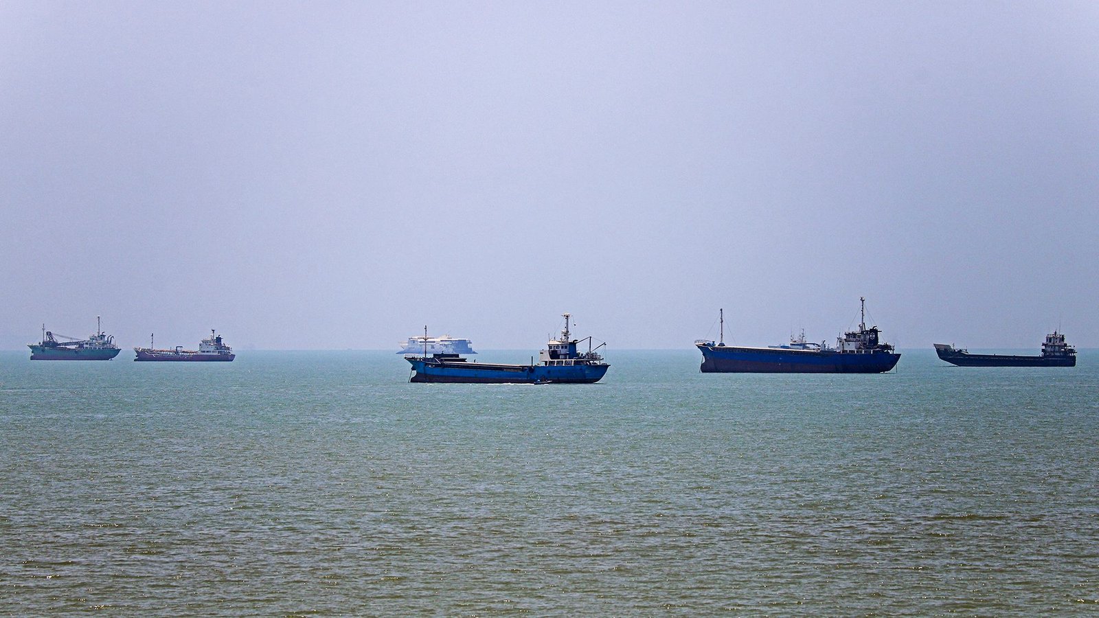 TOPSHOT – This image obtained by Iranian news agency ISNA on June 18, 2026 shows ships anchored in Bandar Abbas along the Strait of Hormuz. Oil prices fell after Trump and his Iranian counterpart separately signed an agreement to end the war in the Middle East with the opening of the Strait of Hormuz, but there are still two months of negotiations ahead. (Photo by AMIRKHOSSEIN KHORGOOI/ISNA/AFP via Getty Images)/