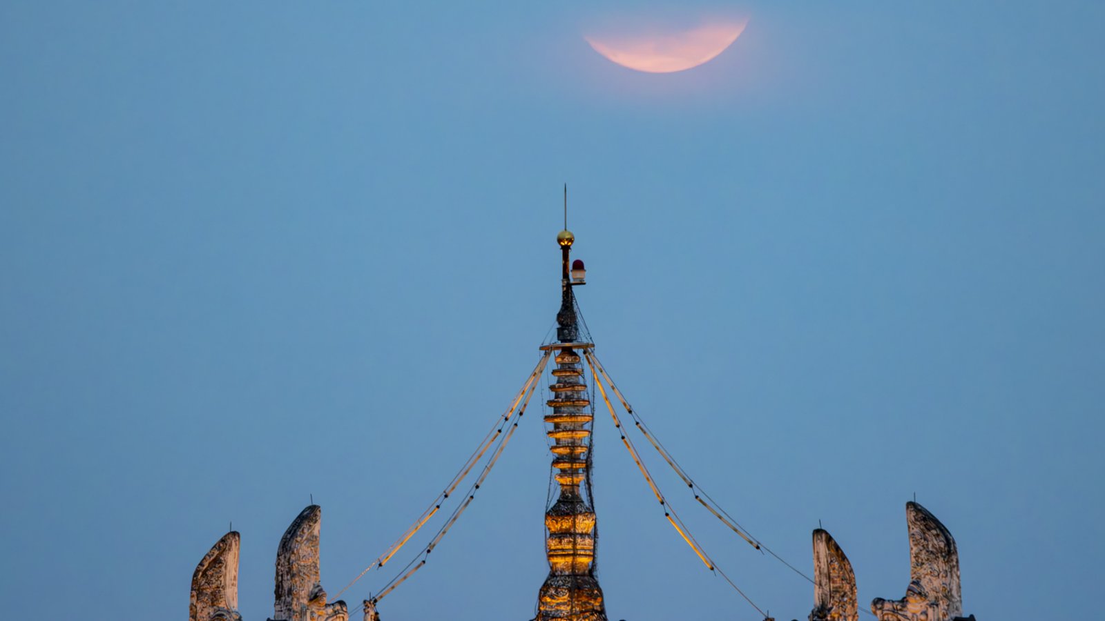 June's Strawberry Moon will be a welcome treat for skywatchers around the world. Here are our favorite photos 26 a thin sliver of the full moon, appearing hazy pink, above the ornate structure on the roof.