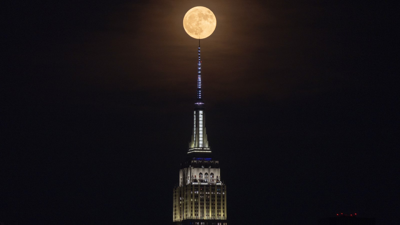 June's Strawberry Moon will be a welcome treat for skywatchers around the world. Here are our favorite photos 22 The fully illuminated moon appears at the very top of the Empire State Building.