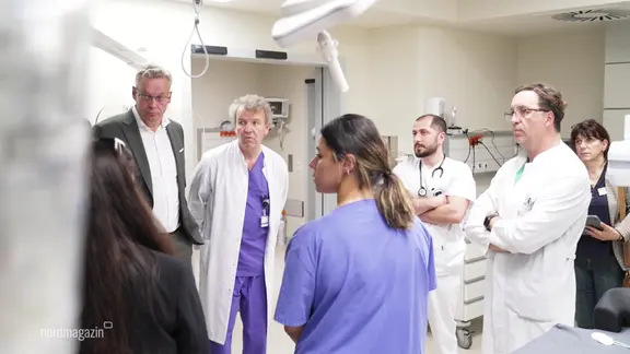 A group of doctors in a clinic. | Screenshot A group of doctors in a clinic.