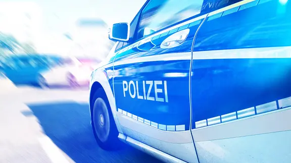 Close-up of a German police car with blue lights on the street | Smarterpix/chris77ho Close-up of a German police car with blue lights on the street