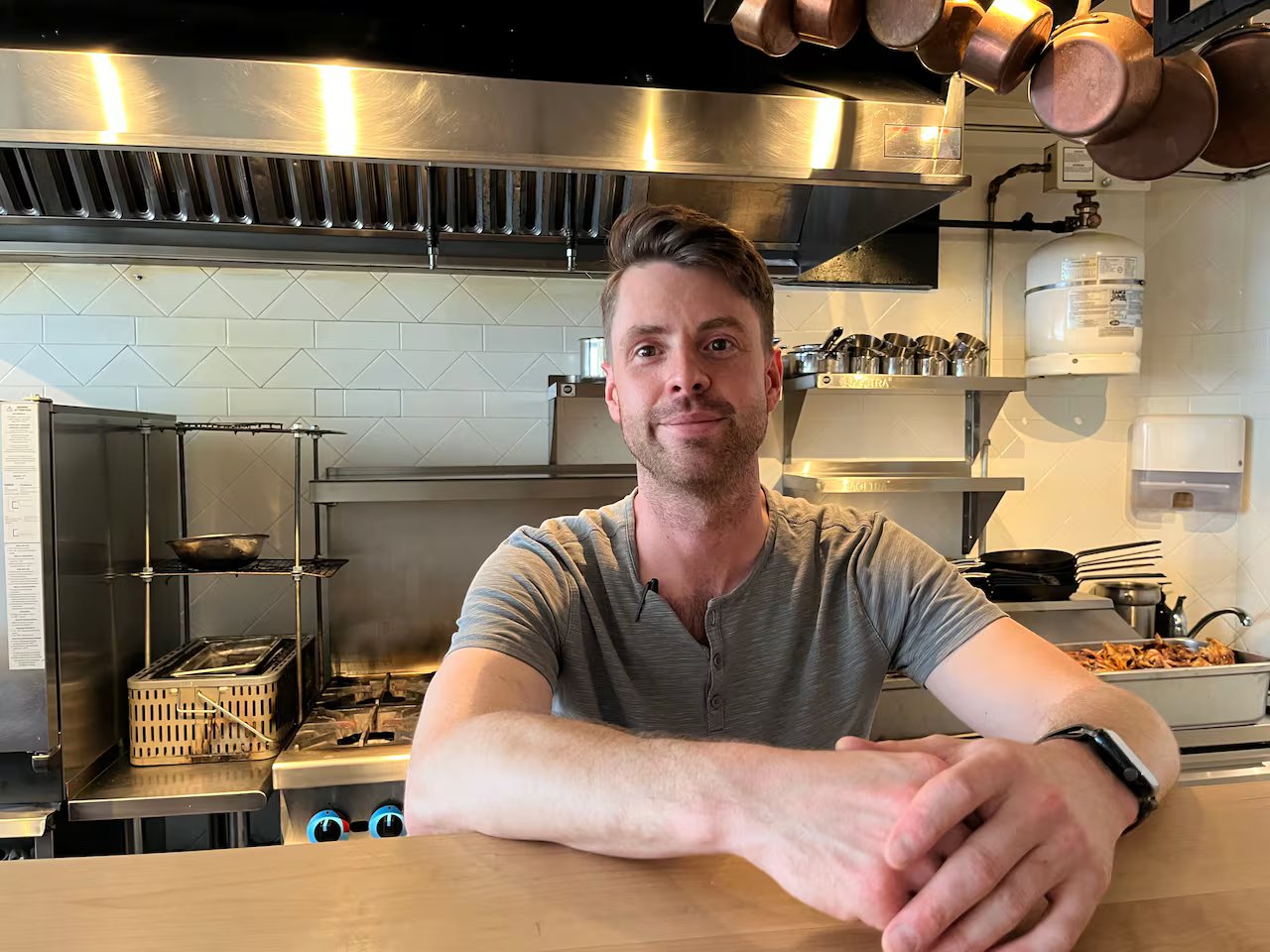 A man with short brown hair is standing in the kitchen.