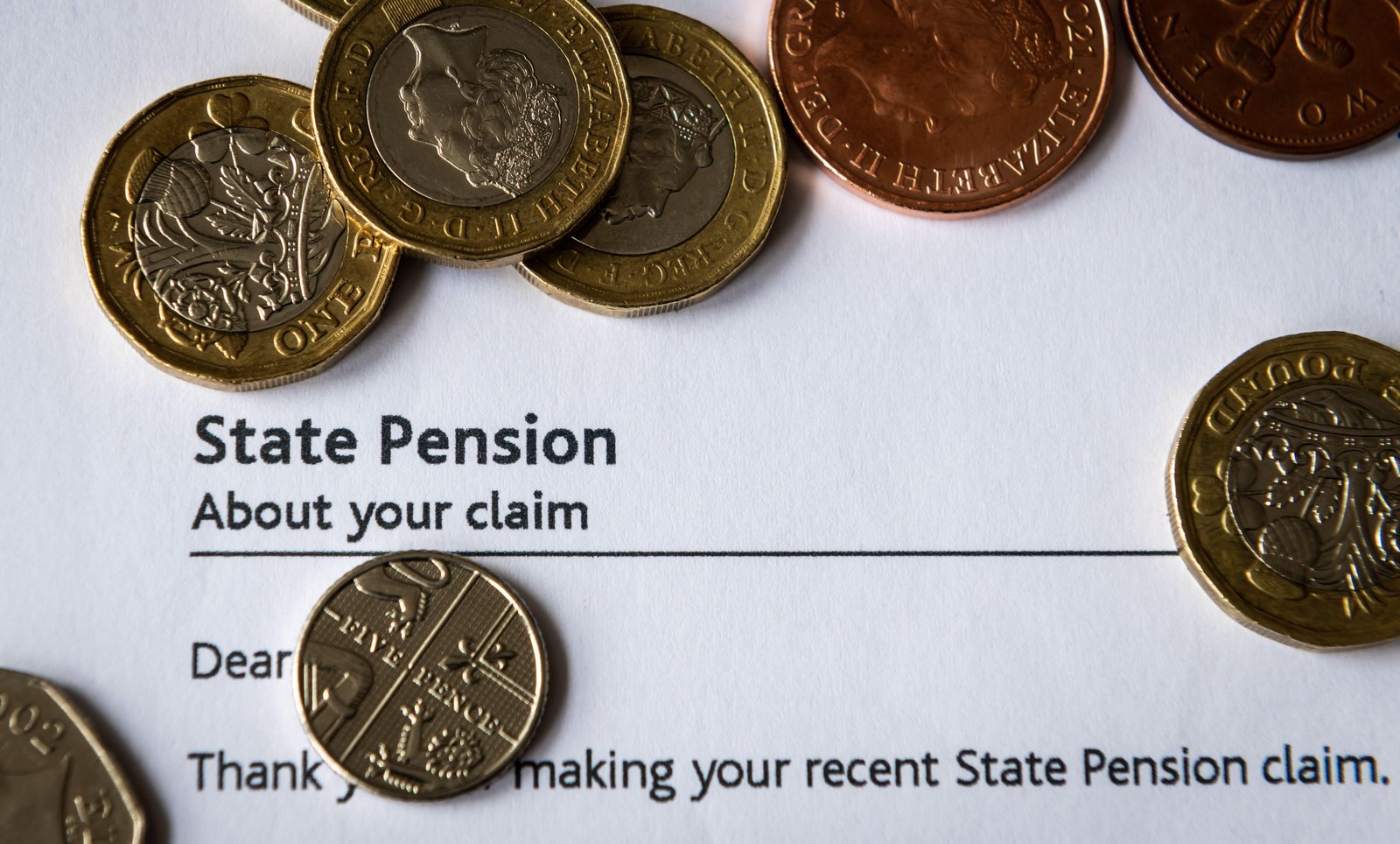 Coin on top of State Pension application letter 