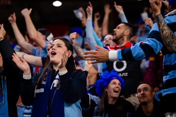 Blues fans celebrate in the crowd at Suncorp Stadium.