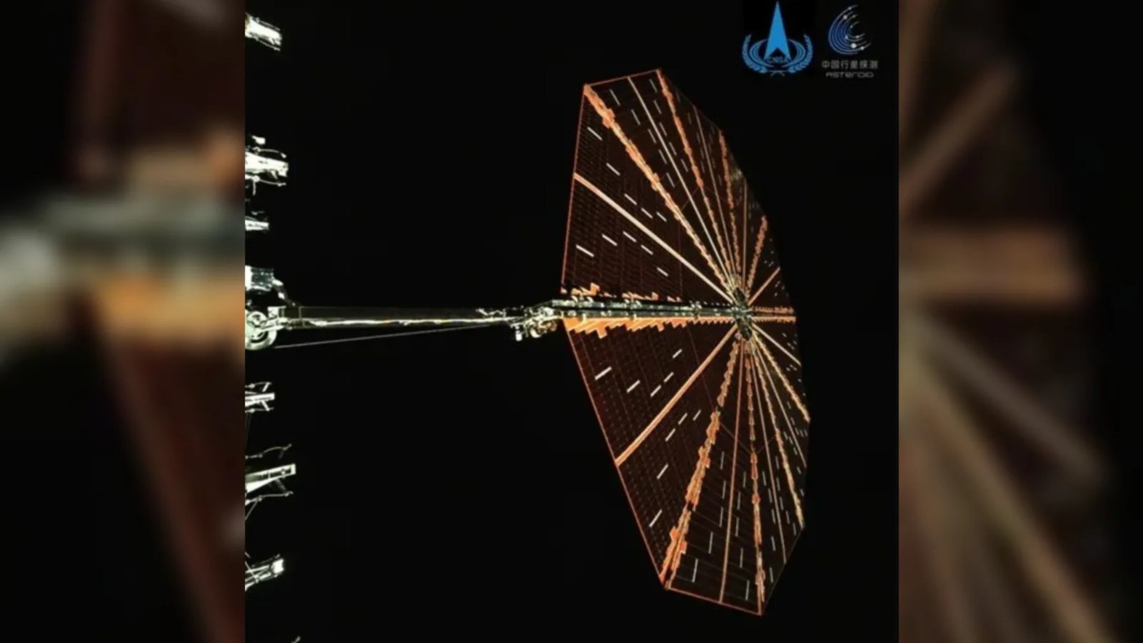 an octagonal solar panel on the end of a metal arm protruding outward from a metal rectangle, out of view on the left side of the image.