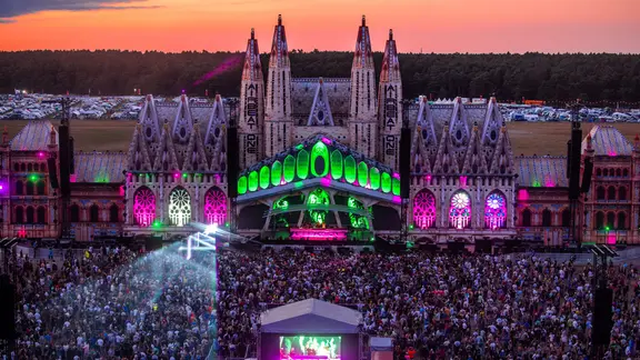 Music fans dance in front of the main stage of the Airbeat One festival after sunset. | photoalliance/dpa | Jens Büttner Music fans dance in front of the main stage of the Airbeat One festival after sunset.