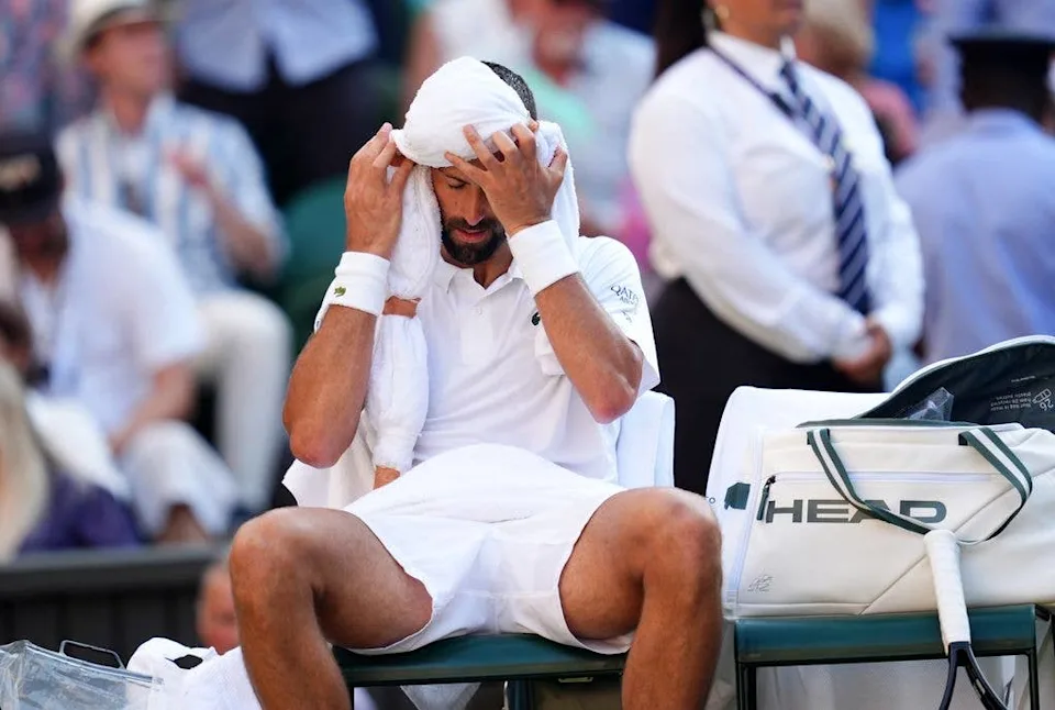 Novak Djokovic takes breaks between games during the men's singles semifinal match against Jannik Sinner.