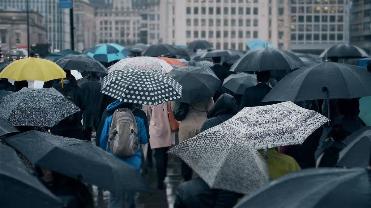 UK weather forecast: 200 mile rain bomb to hit 25 counties - full list 13 Passengers with umbrellas in the rain.
