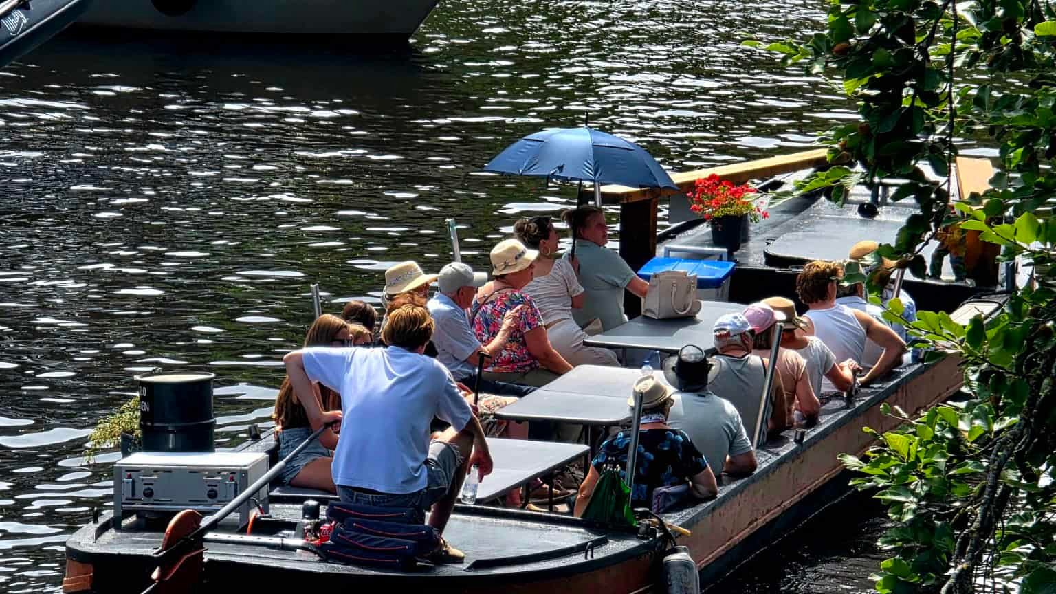 Passengers enjoy a boat ride on the Zwolle canal in sunny summer weather.