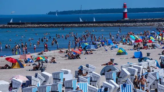 People on the beach and in the Baltic Sea in Warnemünde in summer.