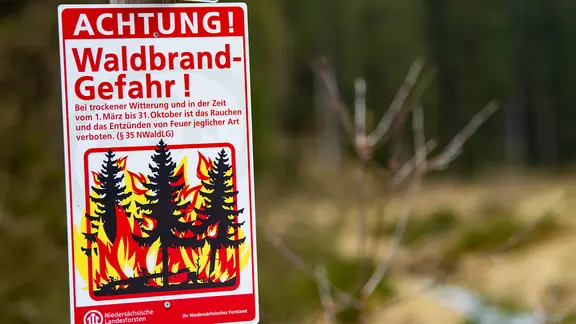 A warning sign drawing attention to the increased risk of forest fires.