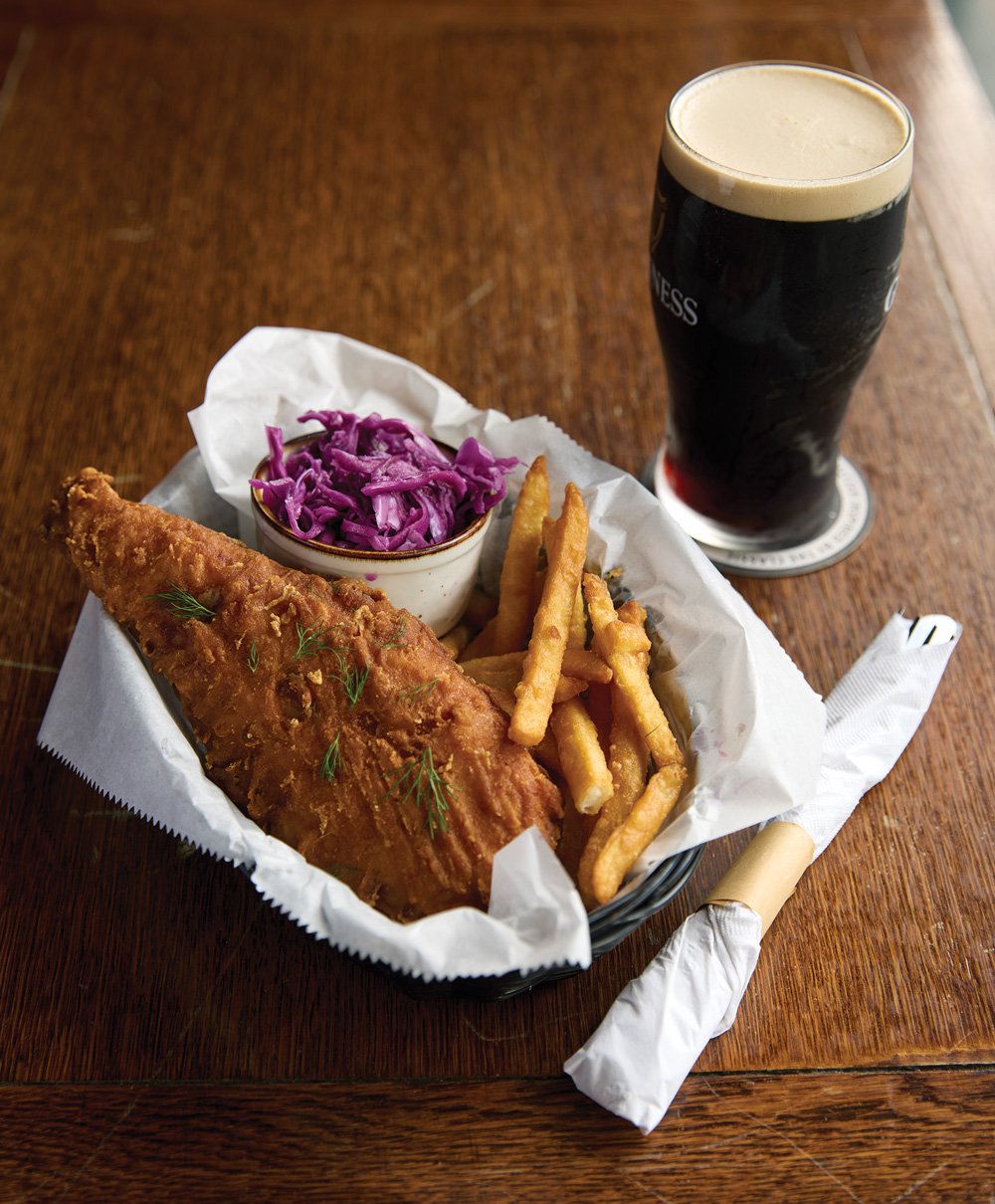 fish and chips next to a glass of Guiness beer