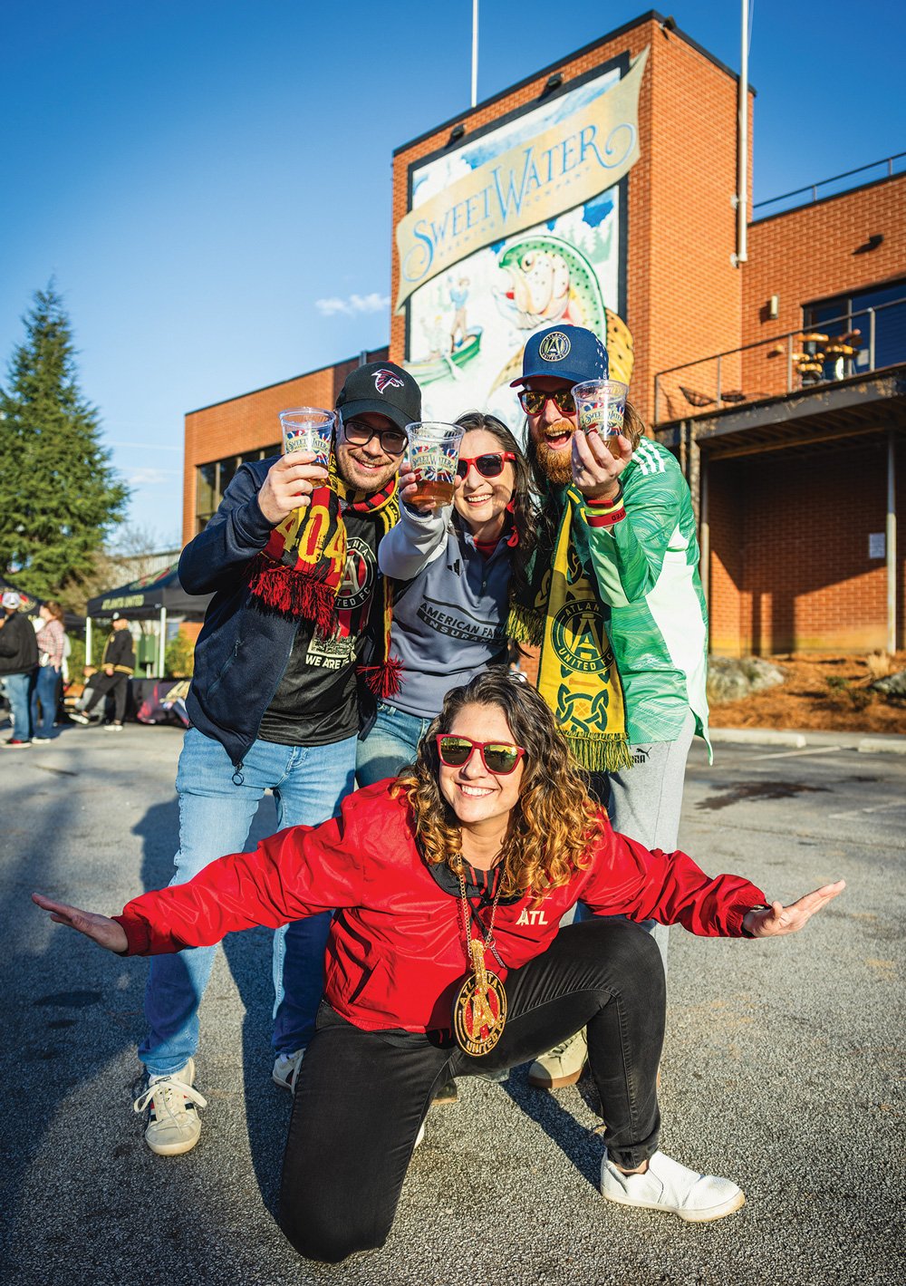 group of friends smiling outside Sweetwater Brewing Company