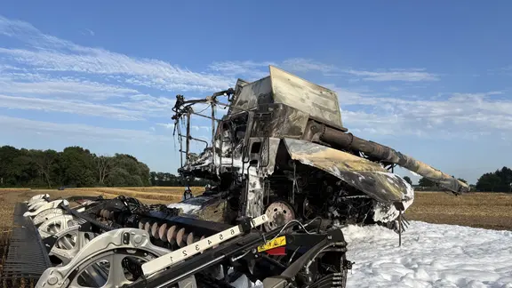 Burnt out combine on a grain field