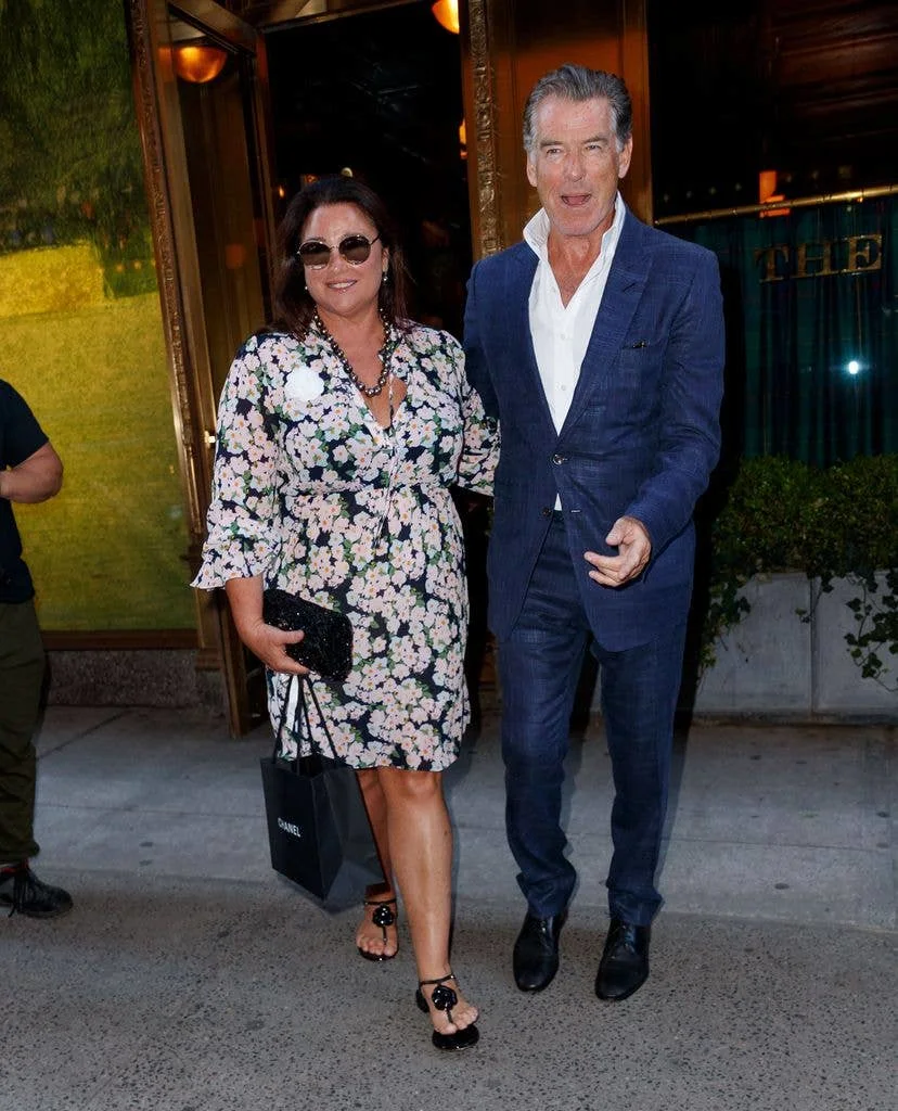 Pierce Brosnan and Keely Shay leave the building, smiling