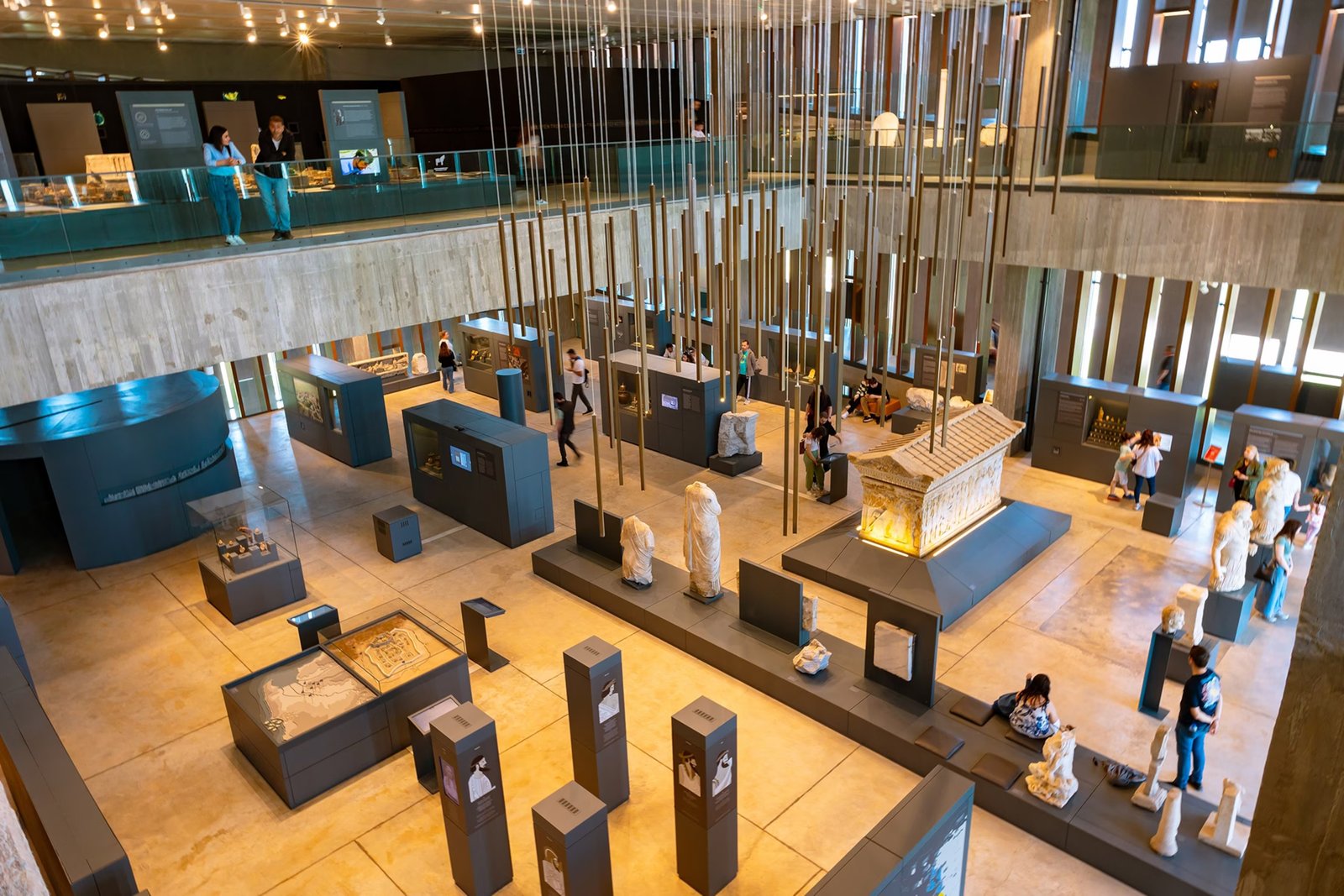 View from the balcony of the museum hall filled with artifacts, posters and visitors.