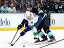 The Kraken's Jamie Oleksiak connects with the Canucks' Jake DeBrusk during a game on March 1, 2025, at Climate Pledge Arena in Seattle.
