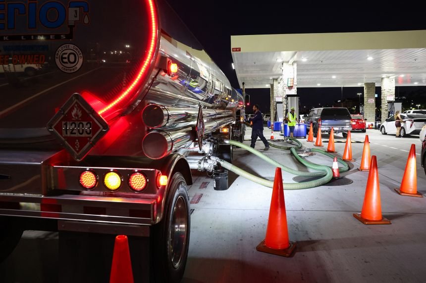 Workers prepare to unload a shipment of gasoline at a gas station in Hawthorne, California, on March 18 after gas prices rose due to the conflict with Iran.