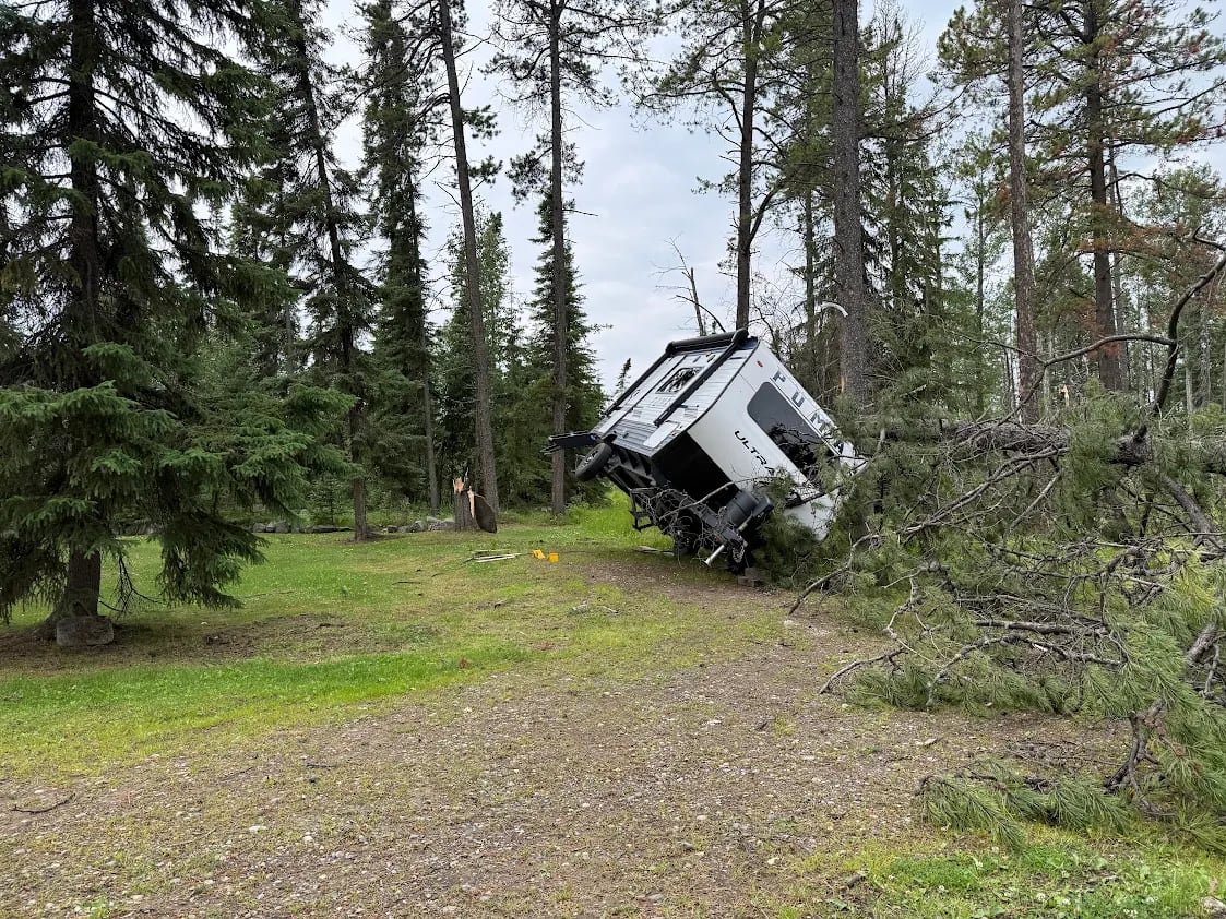 A tree was uprooted and the mobile home fell onto its side.