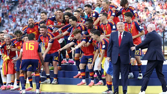 FIFA President Gianni Infantino begins to drag President Donald Trump away from Spain's trophy celebrations.