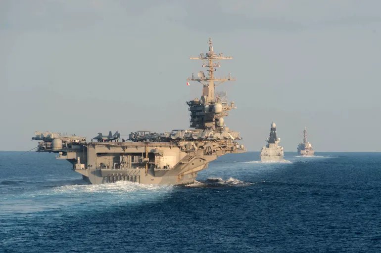 (FILES) (LR) Aircraft carrier USS Abraham Lincoln (left), air defense destroyer HMS Defender and guided missile destroyer USS Farragut pass through the Strait of Hormuz (AFP)