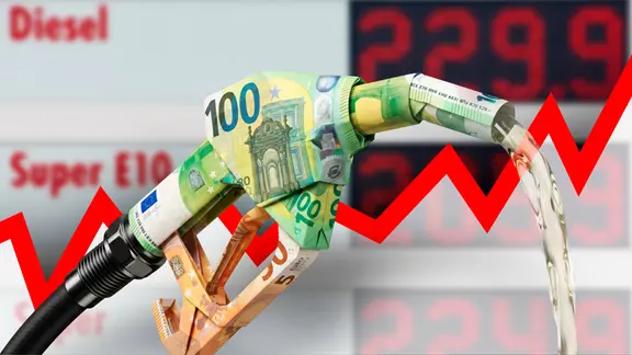 Fuel injector made of folded euro bills in front of a price board at a gas station and an ascending graph, a symbolic image on the theme of high fuel prices | IMAGO/IlluPics A fuel injector made of folded Euro bills in front of a price tag at a gas station and an ascending graph, a symbolic depiction of the theme of high fuel prices.
