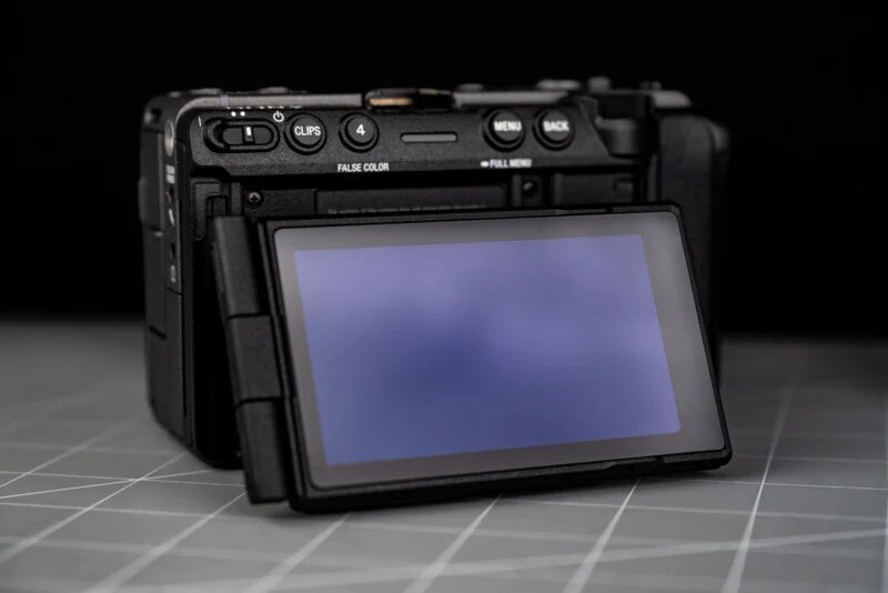 Sony FX5 has a new sensor, open shutter, internal RAW and more 32 The digital camera, with its rear LCD screen turned out, was facing forward. The camera is placed on a gray surface with a grid, and the background is black.