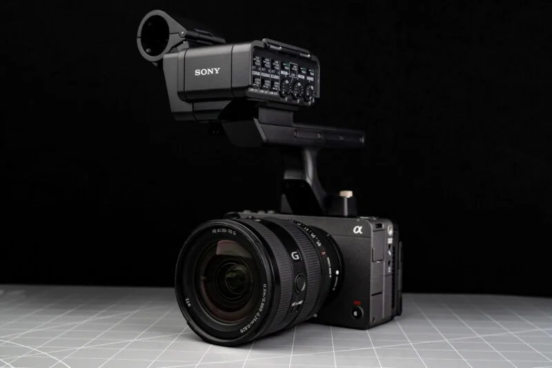 Sony FX5 has a new sensor, open shutter, internal RAW and more 33 A professional Sony digital video camera with a large lens and an external audio interface sits on a gray surface with a grid pattern on a black background.