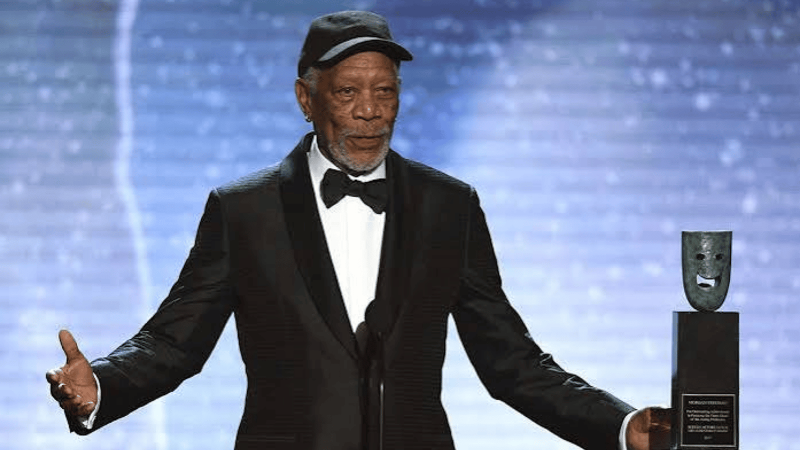 Morgan Freeman's Wealth and Income Distribution 15 Morgan Freeman, wearing a tuxedo and cap, holds an award on stage at the event.