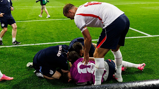 Team medics help Henderson after he fell onto a billboard.