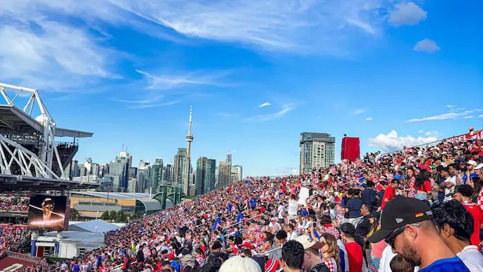 Football fans at the stadium with Toronto in the background.