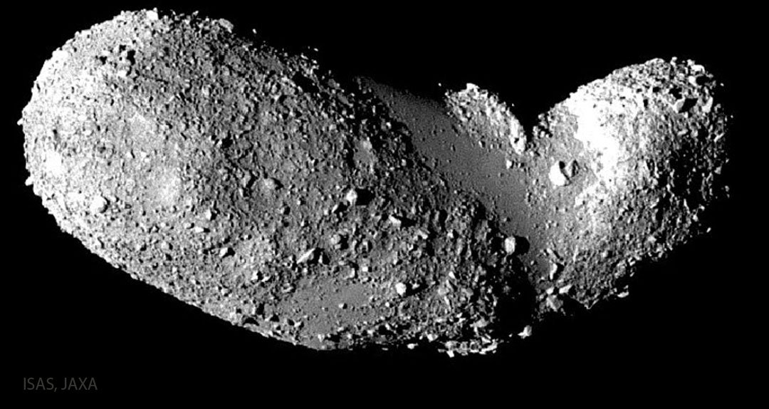 The dark space is surrounded by a gray object the size of a peanut. The surface of the object has many rough nodules, as well as several relatively smooth areas. Please see explanation for more details.