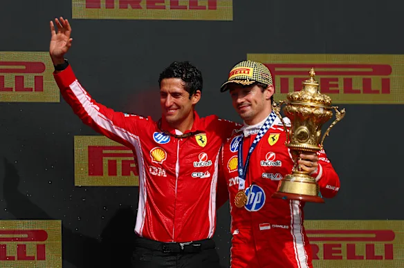 Race winner Charles Leclerc from Monaco and Brian Bozzi, race engineer for Scuderia Ferrari, celebrate their victory on the podium.