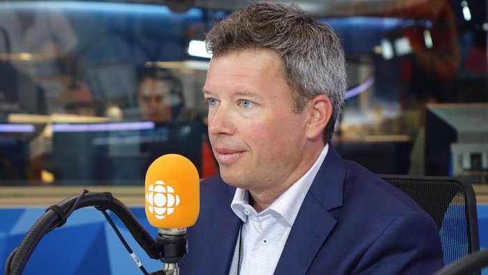 Louis Aucoin in front of a microphone in the Radio-Canada radio studio.