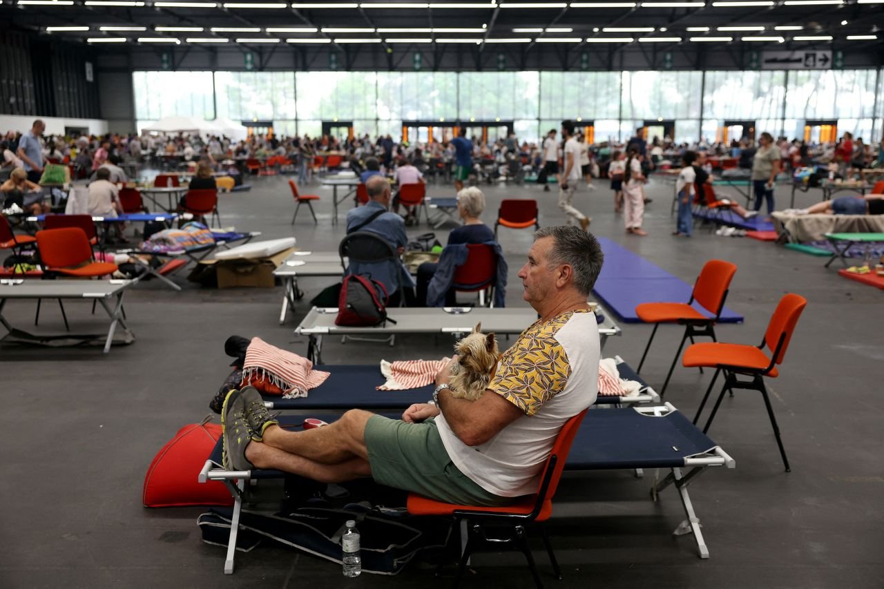 A man evacuated due to bushfires holds his dog as they take shelter in Bordeaux's Exhibition Park on July 25.