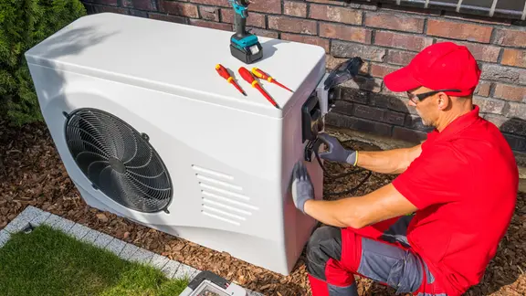 Man with tools at a heat pump