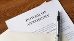 Powers of attorney are on the table, there is a silver pen on the papers.