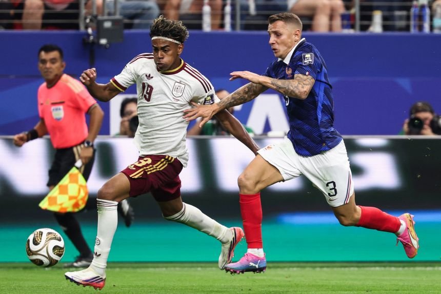 Spaniard Lamin Yamal rushes down the flank, while Frenchman Lucas Digne defends.