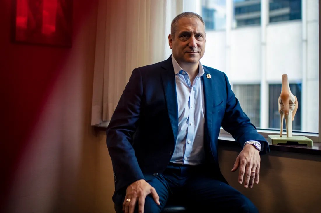 Gian Corrado leans against a glass window to take a portrait.