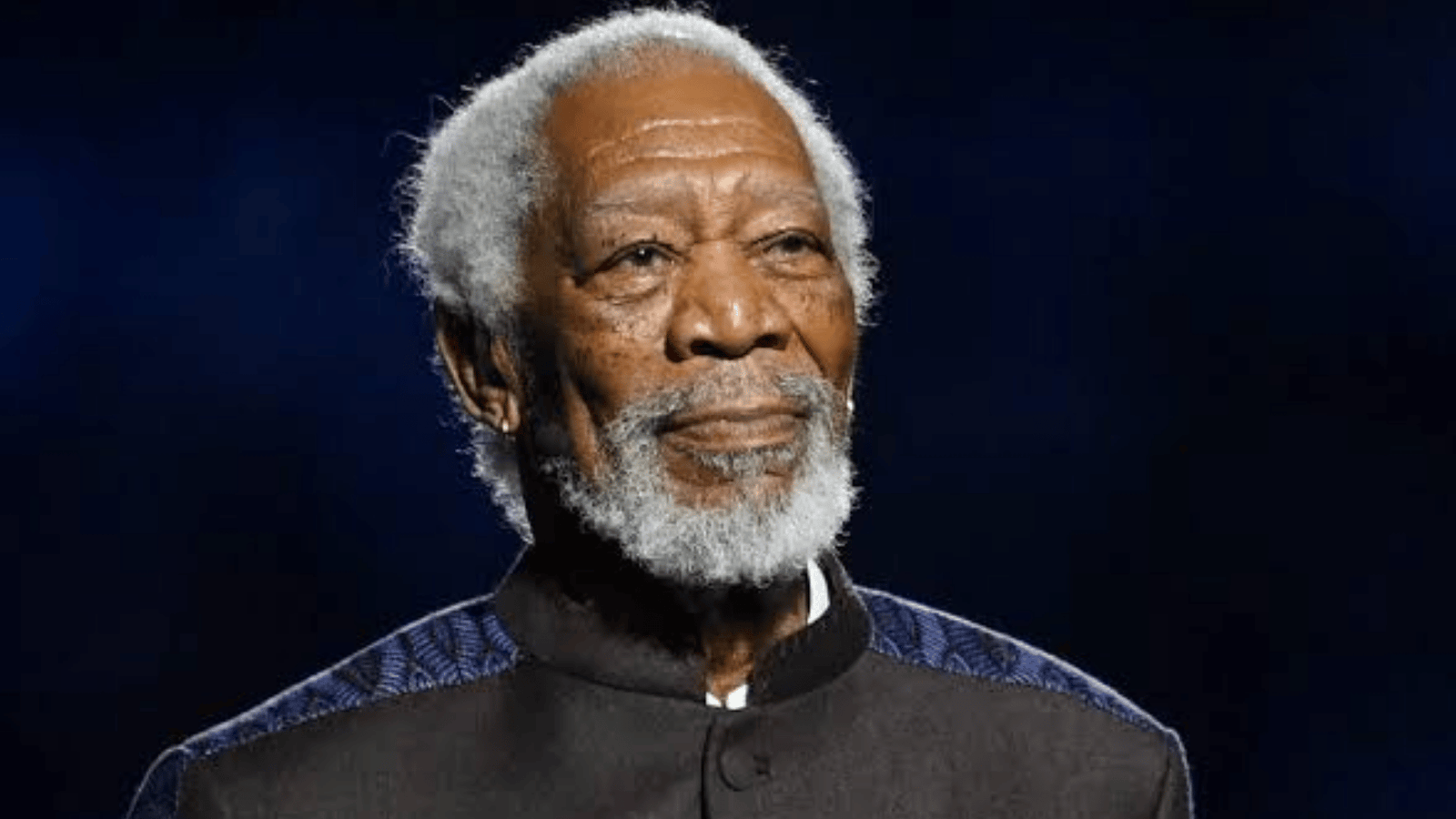 Morgan Freeman's Wealth and Income Distribution 13 Morgan Freeman stands on stage in a dark suit during a public appearance.