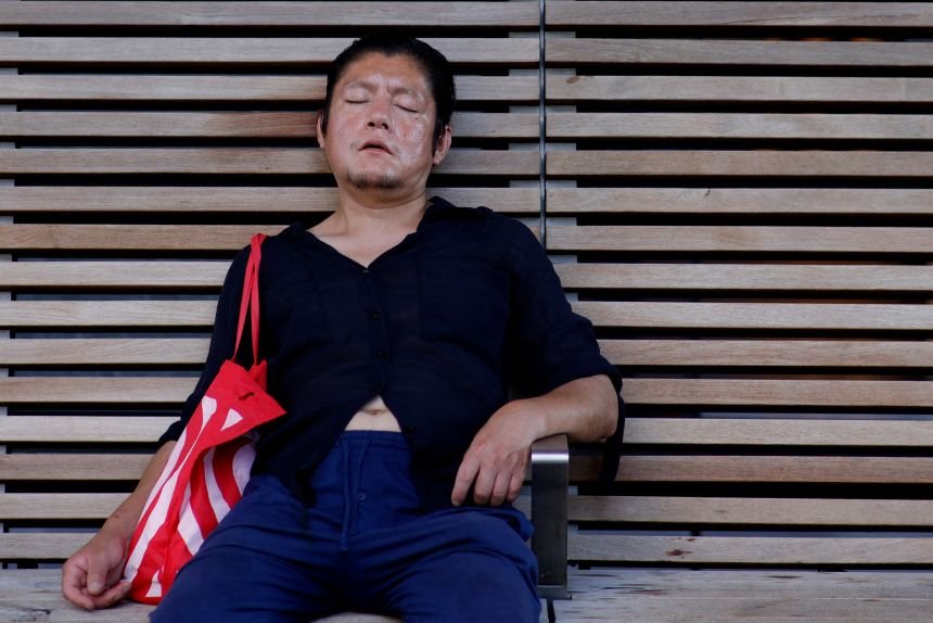 A man relaxes in the shade on a bench in midtown Manhattan during a heat wave in New York City on Friday, July 3.