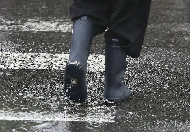 Citizens wearing boots move through Gwanghwamun Square in Jong-gu, Seoul, on the 20th after rain. /News 1
