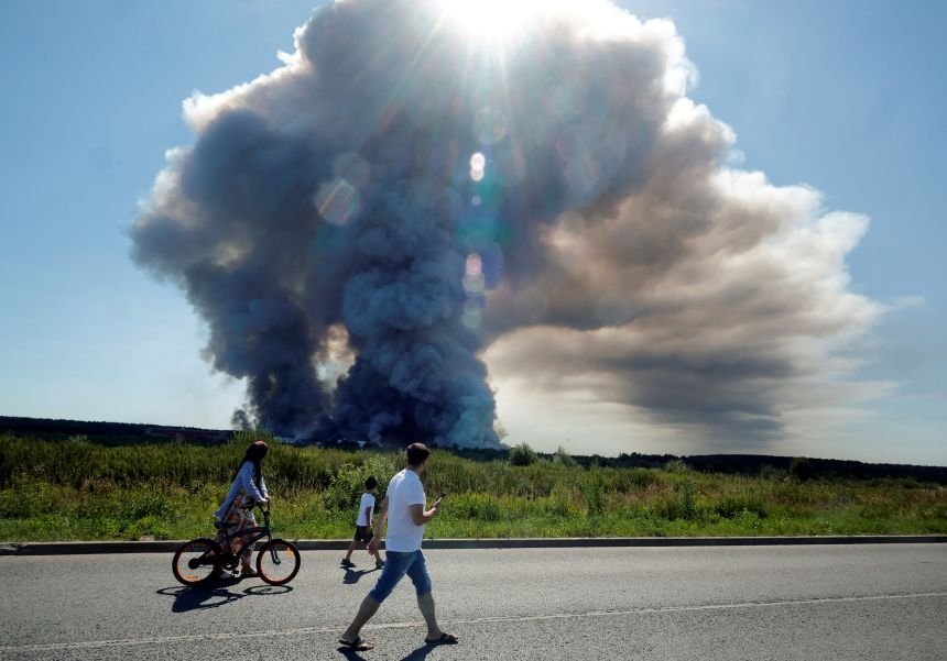 'Up in Smoke': Attacks on the 'Russian Amazon' Bring Putin's War Closer to Home 13 Local residents walk past smoke from a fire at the Russian e-commerce logistics complex Wildberry in the town of Elektrostal near Moscow on July 18.