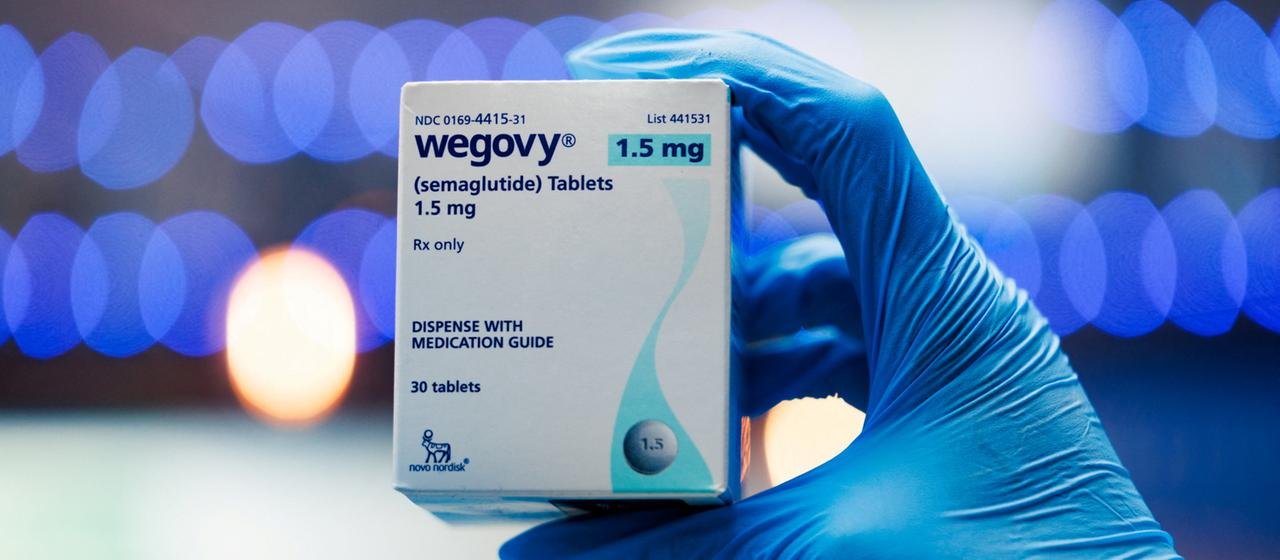 A man holds a pack of Wegovy tablets.