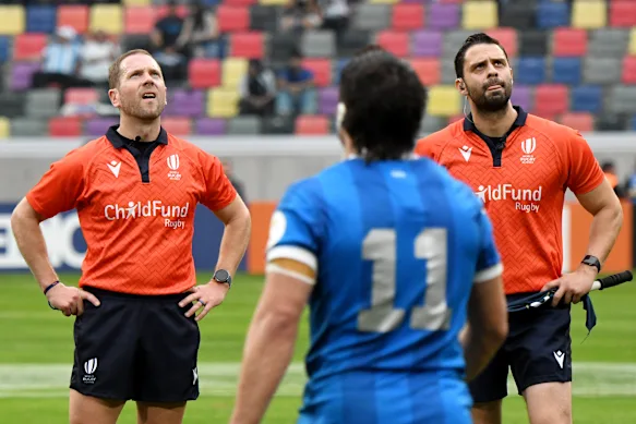 Angus Gardner (left) watches the TMO review the England v Argentina decision on the big screen.