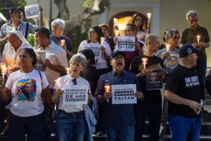 People hold signs and lit candles at a vigil to pray for the release of political prisoners in Caracas, Venezuela, 13 September 2026. EPA/MIGUEL GUTIERREZ